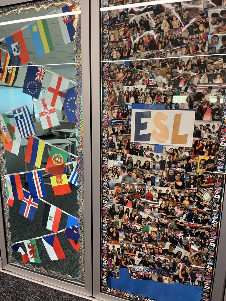 ESL classroom display with world flags and a collage of student photos surrounding a colorful “ESL” sign.