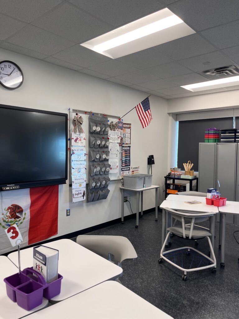 ESL classroom with student supply bins, a digital board, American and Mexican flags, and organized classroom storage.