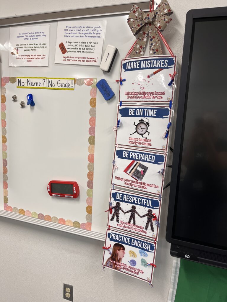 High school ESL classroom expectations beside a no-name work board